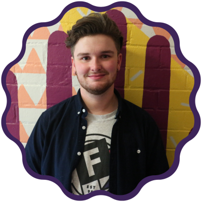 A person wearing freedom logo t-shirt, faces the camera smiling warmly.