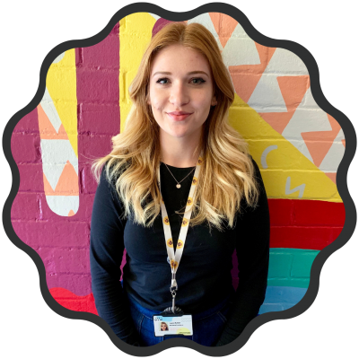 Laura has shoulder length blonde hair and smiles at the camera.