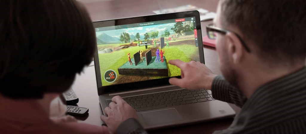 Two people sit facing a laptop, one person points at the pro-real software on the screen.